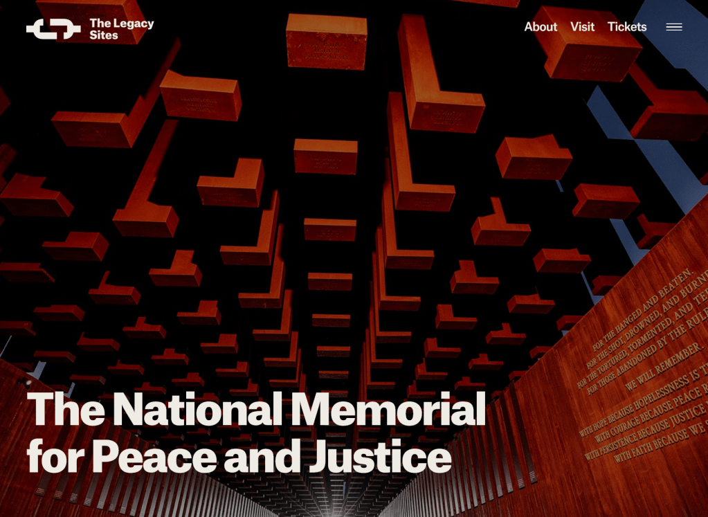 Screenshot of web page from eji.org, showing the hanging iron monuments from below in twilight.